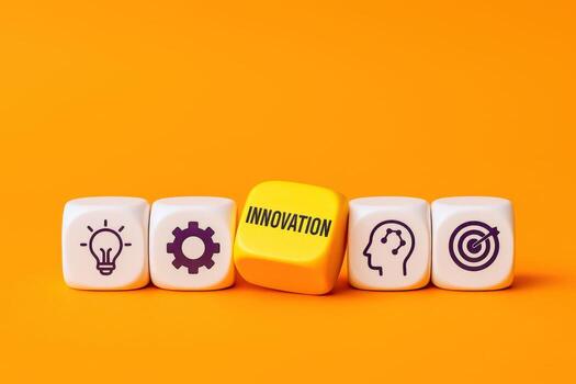 Innovation Concept Dice Illustrating Ideas, Development, Creativity, and Goals on a Vibrant Orange Background, Signifying Progress photo