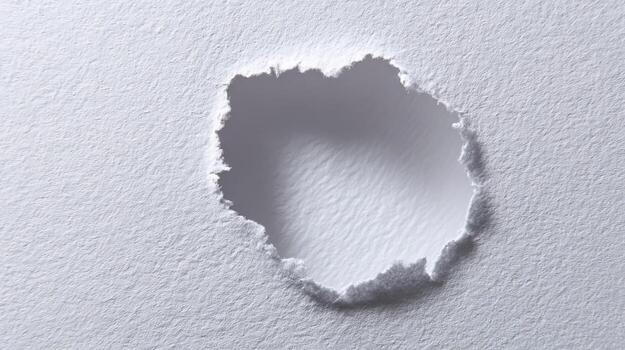 Hole Torn Through White Paper, Revealing Depth and Texture, Ideal for Conceptual Backgrounds and Creative Design photo