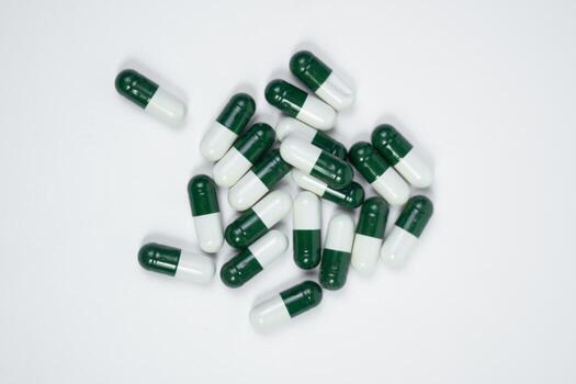 Capsules Packed with Nutrients and Vitamins, white or green capsules on white background photo
