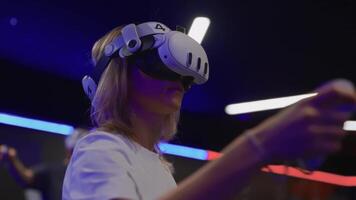 joven mujer en vr auriculares con palancas de mando, completamente inmerso en virtual espacio mientras ajustando juego o programa ajustes. capturas moderno interactivo tecnología experiencia. video