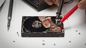 detailopname van gedemonteerd moeilijk rit net zo technicus tests elektronica met multimeter sondes. professioneel gegevens herstel of bestanddeel diagnostiek in voortgang. video