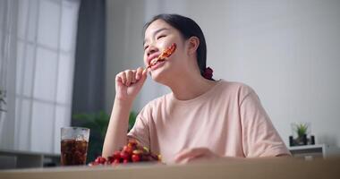 palmare Basso angolo Visualizza sparo, rilassato asiatico donna godendo mangiare grigliato barbecue in casa video