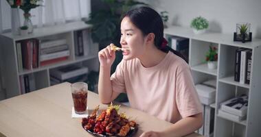 rilassato asiatico donna godendo mangiare grigliato barbecue in casa video
