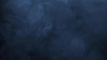 Bluish smoke drifting across dark background. Cool misty overlay effect for atmospheric compositions and moody visual projects. video