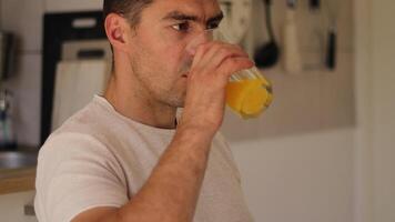 ein Mann sitzt bequem beim Zuhause genießen seine Frühstück. er Getränke erfrischend Orange Saft während genießen flauschige Gebäck, Erfassen ein friedlich Morgen Moment gefüllt mit einfach Freuden video