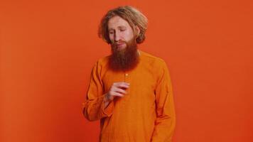 bisogno alcuni Di più, per favore dare me. caucasico uomo mostrando un' poco po gesto con scettico Sorridi mostrando minimo cartello, misurazione piccolo dimensione accattonaggio aiuto. testa Rossa tipo isolato su arancia studio sfondo video