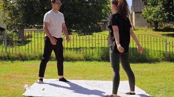 nel un' tranquillo, calmo Giardino dietro la casa ambientazione, un' coppia impegna nel esercizio routine, messa a fuoco su squat e lavoro di squadra. essi Condividere qualità tempo mentre valorizzare loro fitness livelli e relazione video