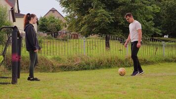 A couple engages in a friendly soccer match in their backyard, demonstrating teamwork and enjoyment. They pass the ball back and forth while laughing and having fun together video