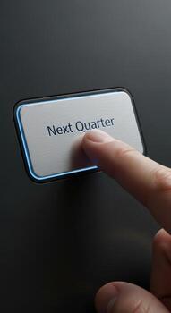 Finger pressing a button labeled next quarter on a dark surface photo