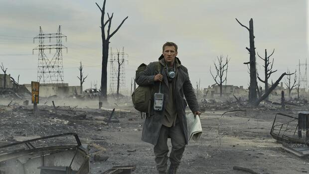 Survivor Walks Through Desolate Landscape With Ruins and Power Lines in the Aftermath of a Disaster photo