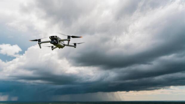 Drone Hovering Under Dramatic Storm Clouds Over an Open Landscape in Late Afternoon photo