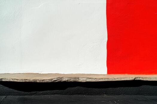 Brightly colored wall with red and white sections and natural stone base photo