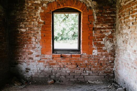 Abandoned room with brick walls and a window overlooking greenery photo