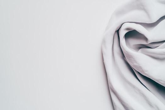 Soft white fabric draped gracefully on a minimalistic surface photo