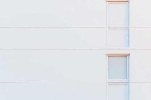 Minimalist architecture featuring windows on a white facade in daylight photo