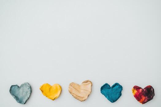Colorful paper hearts arranged in a creative layout on a light background photo