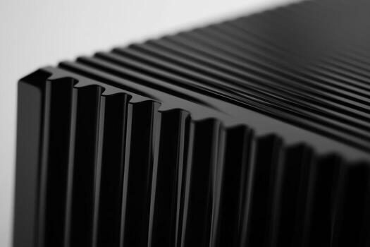 Close-up view of a textured black surface featuring vertical grooves photo