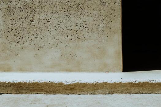 Close-up view of a textured concrete wall with shadows and light patterns photo