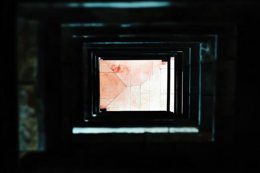View looking down a spiral staircase revealing tiled floor patterns photo