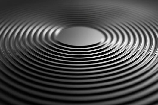 Circular grooves on a black surface create a reflective pattern photo