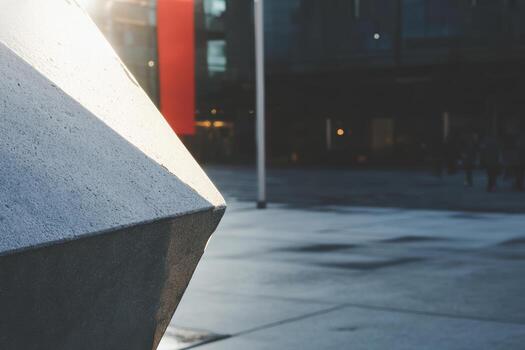 Unique geometric structure casting shadow in urban plaza during late afternoon photo