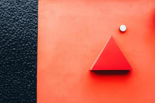 Bold red and black geometric shapes on a textured wall during daylight photo