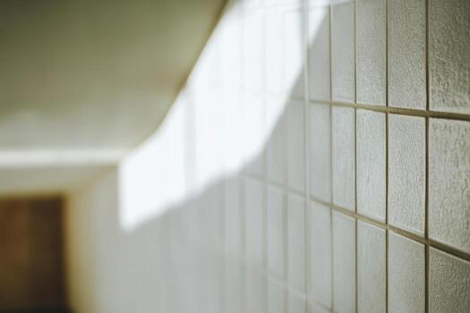 Sunlight casting shadows on tiled wall in a quiet staircase photo