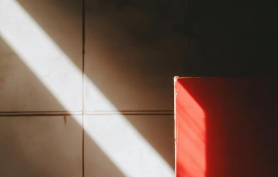 Light beam illuminating a red surface against a textured wall photo