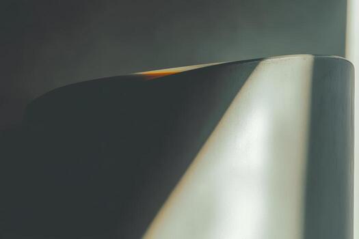Curved edge of a modern sculpture highlighted by soft light photo
