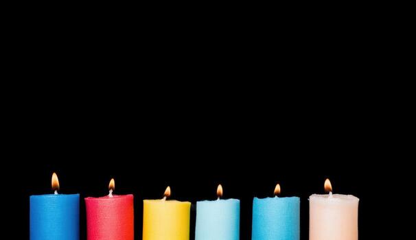 Colorful candles burning in darkness with vibrant flames creating warmth photo
