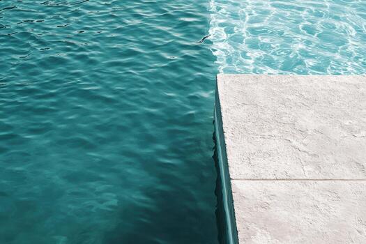 Serene turquoise water contrasting with smooth stone pool edge photo