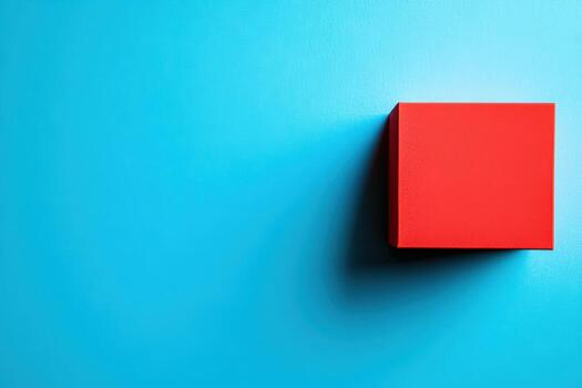 Bright red square box against a vibrant blue background in a minimalist setting photo