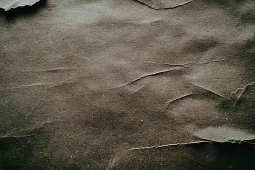 Textured brown paper with creases and torn edges in warm light photo