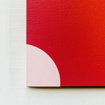 Abstract artwork with red and pink tones on a textured surface photo