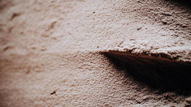 Textured sand with subtle patterns created by wind and moisture photo