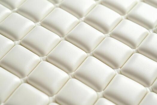 Soft, textured surface of white square cushions arranged in a pattern photo