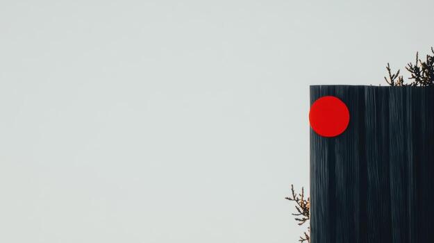 Red circle on dark structure with greenery above on a clear day photo