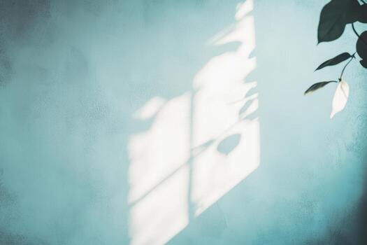 Soft sunlight casts shadows on a textured blue wall in a tranquil space photo