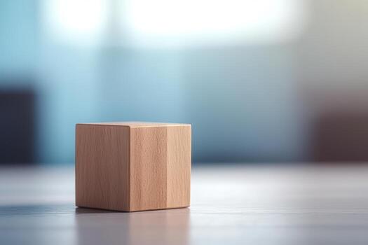 Wooden cube resting on a smooth surface in a softly lit room photo