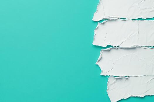 Torn white paper strips on a vibrant turquoise background create contrast photo