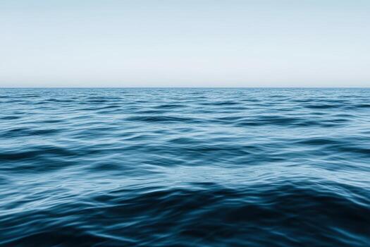 Calm ocean waves under a clear sky at dusk in an open sea environment photo