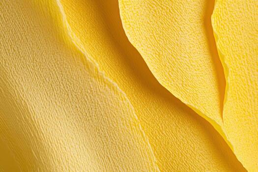 Bright yellow textured fabric draping elegantly in soft waves photo