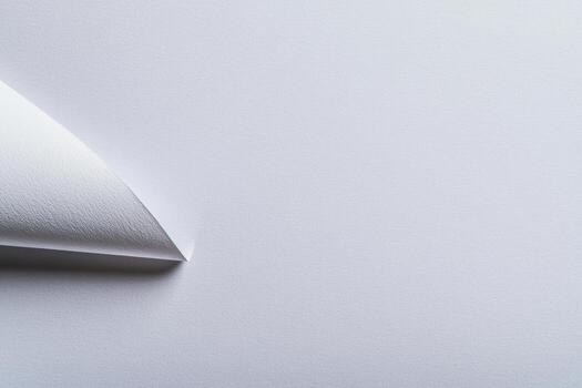 Smooth white paper corner curled revealing textured surface beneath photo