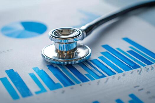 Close-up of a stethoscope resting on medical charts with blue bar graphs and data visualizations symbolizing healthcare analytics and diagnostics photo