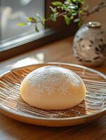 Soft Mochi Dessert Dusted with Powdered Sugar on a Woven Plate photo