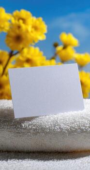 A white card on a towel with yellow flowers in the background photo