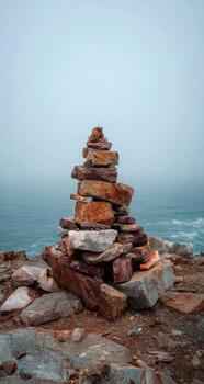 A stack of rocks on top of a hill near the ocean photo