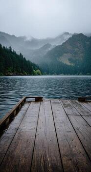 A wooden dock on a lake with trees in the background photo