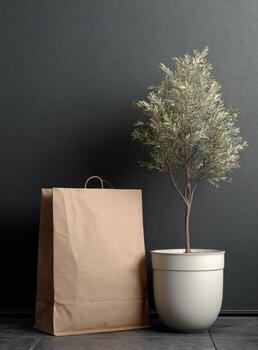 A paper bag and a potted tree on a grey floor photo