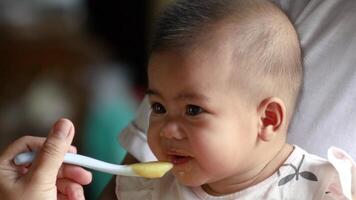 feeding a newborn baby, close-up face portrait, infant smiling and laughing happily, a cute baby thai, asia kid, little baby, asian family lifestyle video
